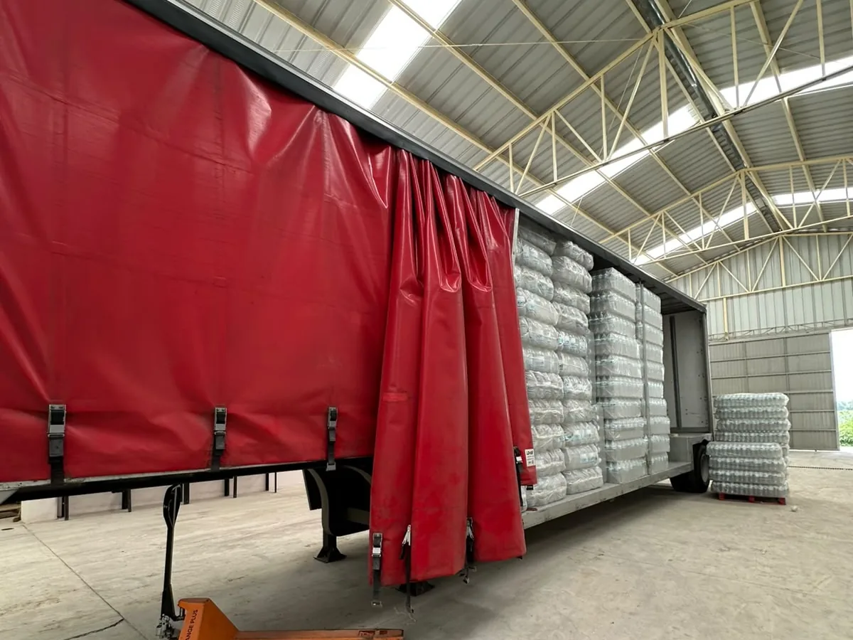Tráiler cargándose con envase estibado dentro de la nave