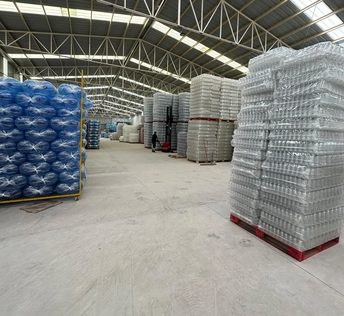 Almacén de botella PET en tarimas con montacargas